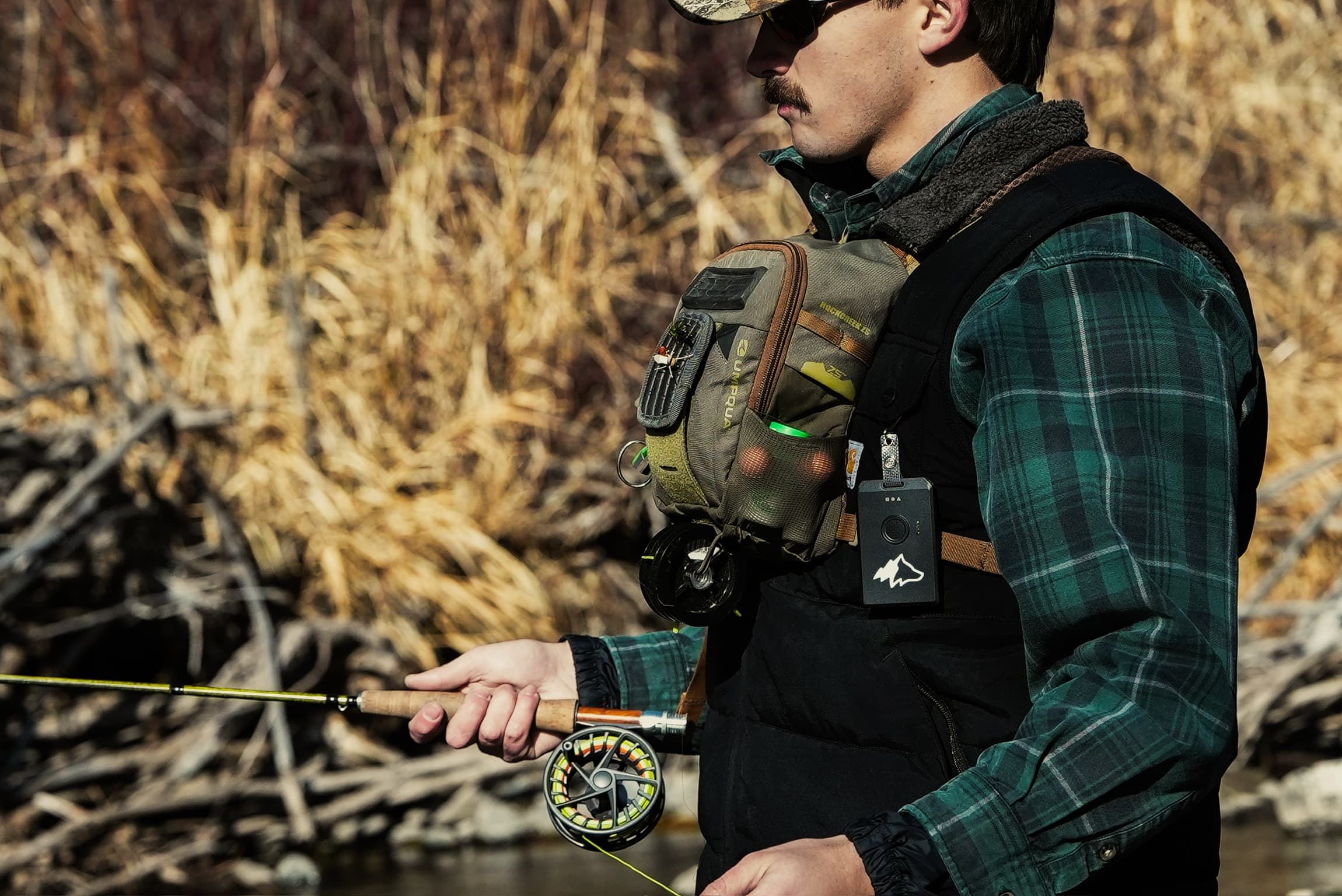 Fly fisherman with Kiba device on chest in the backcountry
