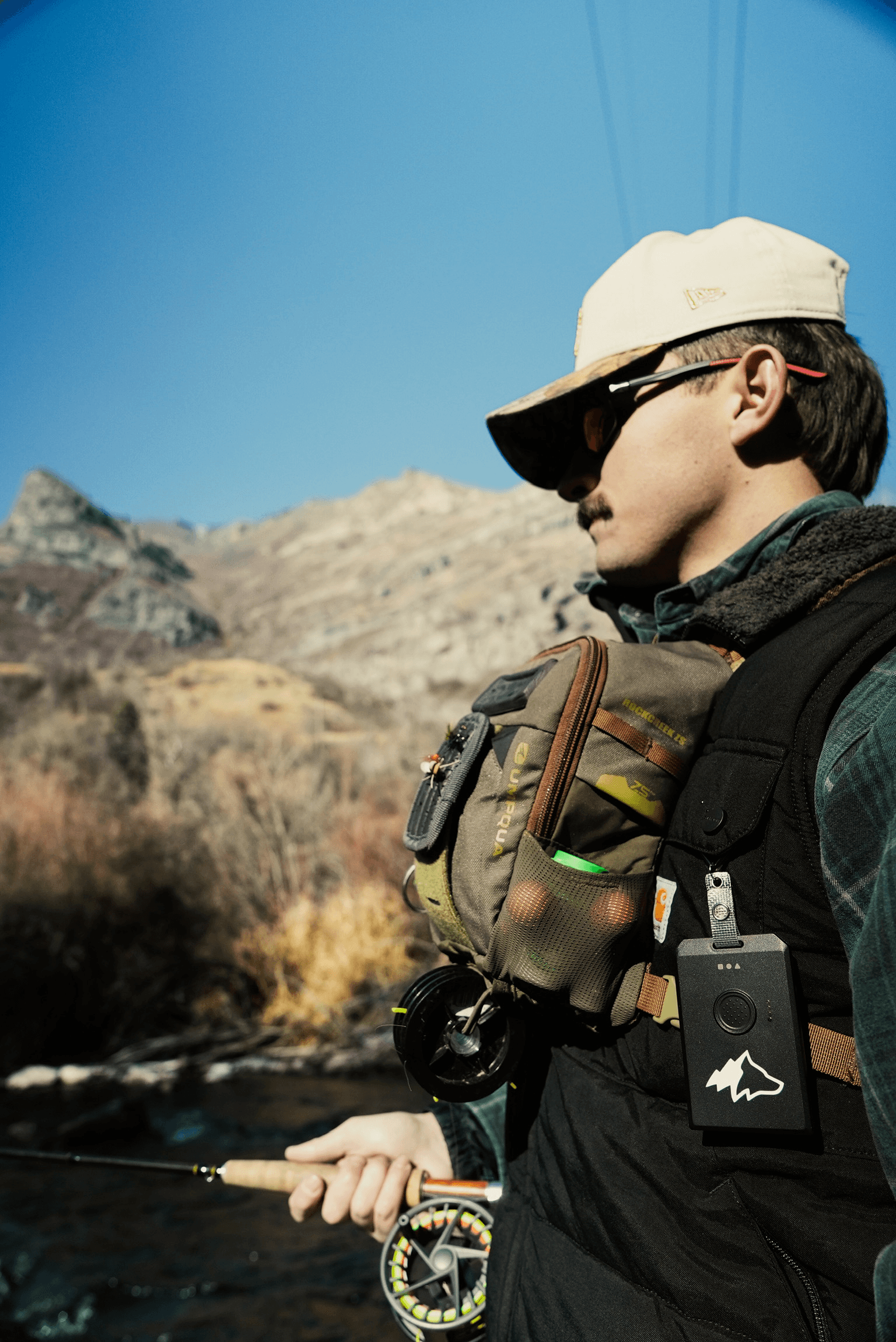 Fly fisherman with Kiba device on chest in the backcountry